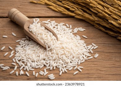 Heap of uncooked Thai sticky rice on wooden table with copy space - Shutterstock ID 2363978921