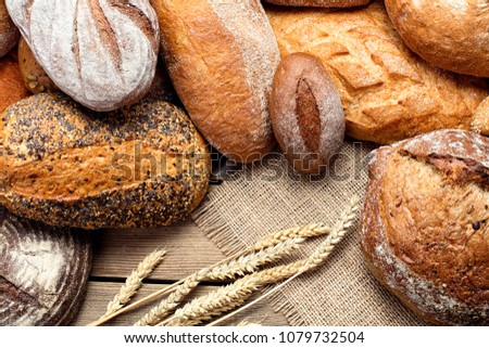 heap of various bread with ears of wheat and burlap