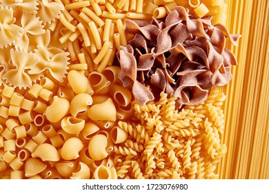 Heap Of Various Raw Pasta Or Macaroni In Different Types And Shapes. Overhead View. 