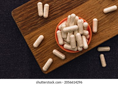 heap of white capsules close-up. niacin dietary supplement capsules on wooden board. immune support medical concept