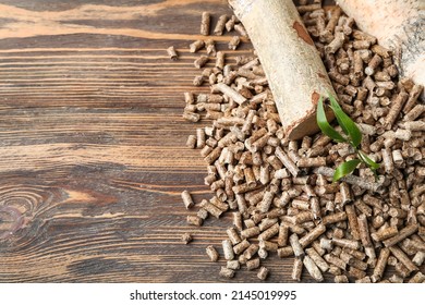 Heap of wood pellets and logs on wooden background