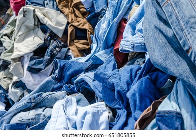 Heaps of clothing on the second hand market. Pile of second hand clothes at a garage sales
