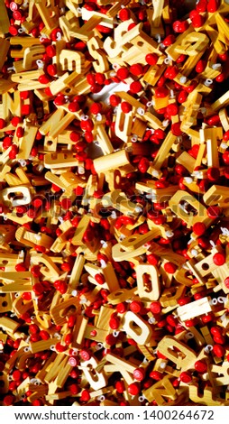 Heaps of wooden letter-shaped toy trains with red wheels in a local market stall in the morning sun