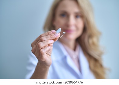 Hearing aid with graceful hand of woman medic - Shutterstock ID 2039664776