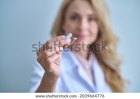 Hearing aid with graceful hand of woman medic