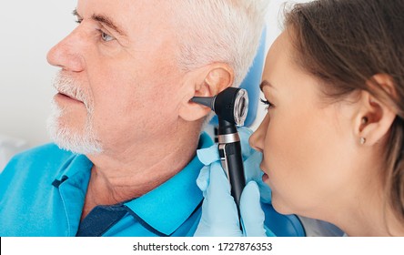 Hearing Exam. Elderly Patient During A Hearing Test, A Doctor With An Otoscope Checking The Hearing Of An Elderly Patient, Close-up