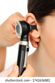 Hearing Exam. Otoscope And Ear Of A Child Close-up Isolated On White. Hearing Test In A Clinic.