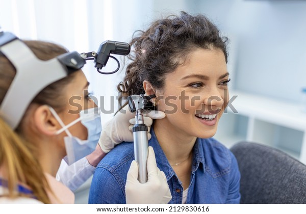 Hearing exam for a woman. Diagnosis of\
impairment and hearing testing in adults. Patient woman during an\
ear check-up with an\
audiologist
