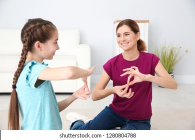 Hearing Impaired Mother And Her Child Talking With Help Of Sign Language Indoors