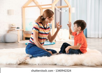 Hearing Impaired Mother And Her Child Talking With Help Of Sign Language Indoors