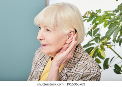Hearing Loss Treatment Concept At Older People. Senior Woman With Hearing Aid Behind The Ear Listens To Ambient Sounds