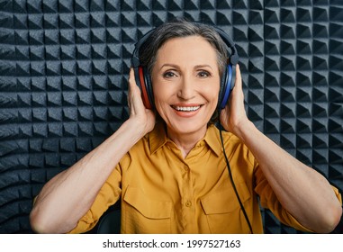 Hearing Loss Treatment. Positive Mature Woman Wearing Audiometry Headphones While Hearing Test And Audiogram In Special Audio Room