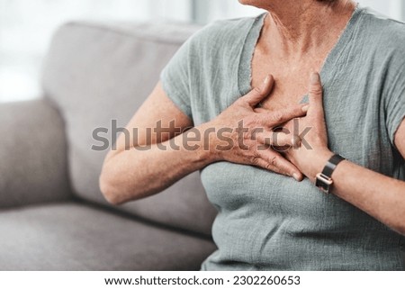 Heart attack, chest pain and sick senior woman with asthma in her home living room or couch with an emergency. Crisis, medical and elderly person with discomfort due to illness or breathing problem
