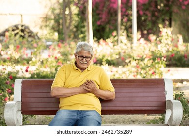 Heart attack concept.. Indian Senior man suffering from chest pain outdoor in park, - Powered by Shutterstock