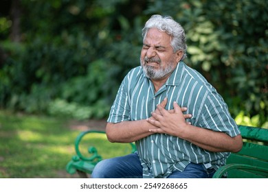 Heart attack concept.. Indian Senior man suffering from chest pain outdoor in park, - Powered by Shutterstock