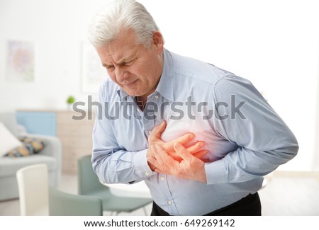 Heart attack concept. Senior man suffering from chest pain indoor