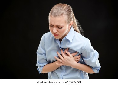 Heart Attack Concept. Young Woman Suffering From Chest Pain On Black Background