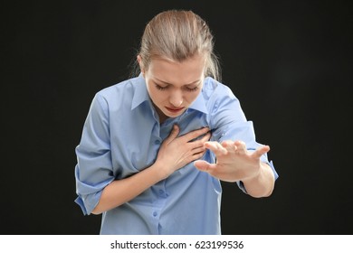 Heart Attack Concept. Young Woman Suffering From Chest Pain On Black Background