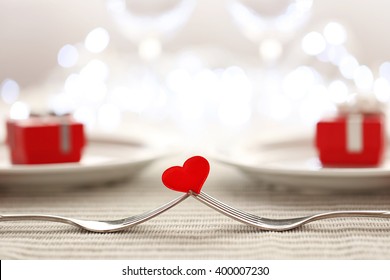 Heart Between Two Forks On A Table Set For Two, Close Up