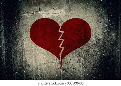 Heart broken painted on grunge cement wall background - love concept