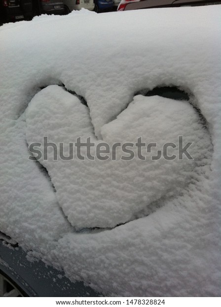 Heart carved in snow on car\
window