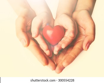 Heart In Child And Mother Hands On Light Background