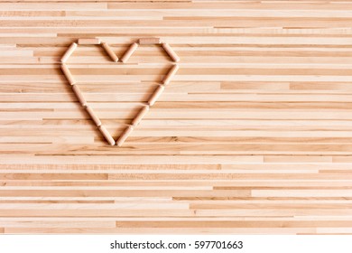 Heart composed of wooden dowels on wooden background. Do it yourself needs. Home Improvement Store. Joinery and carpentry needs. Background with heart. I love you.  Wooden sign and symbol of love.