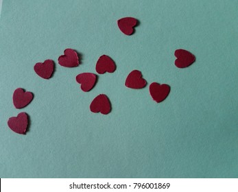 Heart die cut outs from red construction paper on isolated green background