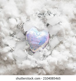 heart in disco colors on a metallic silver snowy iced background.love valentine aesthetic concept idea.frozen heart design