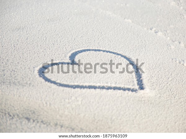 Heart drawn on the fresh white snow. Heart drawn on\
snowy car