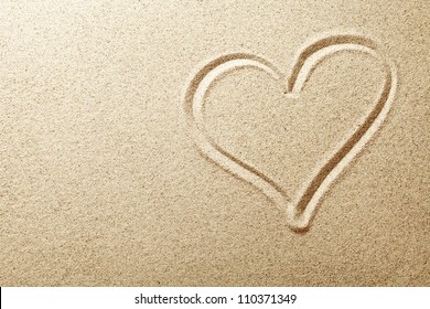 Heart drawn in the sand. Beach background. Top view - Powered by Shutterstock