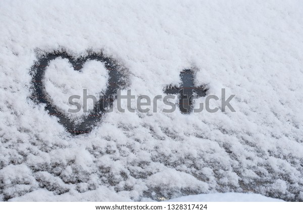 Heart drawn\
in the snow. Black heart on white\
snow.