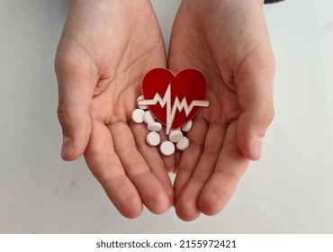 Heart Electrocardiogram Icon And White Pills In Children Hands. Chronic Heart Failure In Children Concept