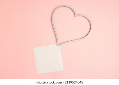 Heart Frame And Square Leaflet Mock Up Blank Template Design Idea. Heart Frame Mockup Against Pastel Pink Background. Copy Space Templates Designs For Message Layout.