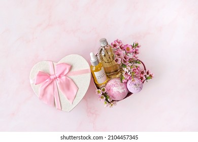 Heart Gift Box With With Spa Treatments And Pink Flowers On Pink Marble Background. Festive Spring Season. 14 February, Valentine's Day, Romantic Gift For Women. Top View