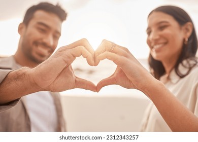 Heart hands, happy and a couple at the beach for love, date and travel together in Bali. Smile, emoji and a man and woman with a shape and hand gesture for romance, ocean holiday and bonding