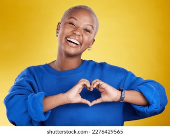 Heart hands, portrait and happy black woman in studio, background and color backdrop for emoji. Smile, female model and finger shape for love, thank you and support of peace, care or sign of kindness - Shutterstock ID 2276429565
