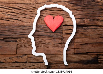 Heart Inside Head Silhouette On Wooden Desk