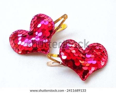 Heart of love red heart shaped hair clips placed on a white background. Close -up shot of hearts.