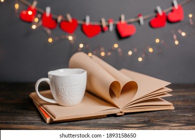 Heart Made From Book Sheets With A Cup, Love And Valentine Concept On A Wooden Table