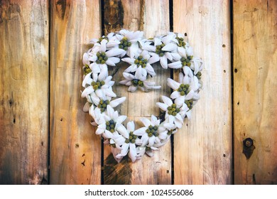 heart made of flowers on wooden background, love concept