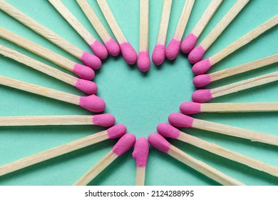 Heart made of new matchsticks on color background, closeup