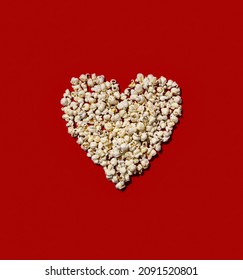Heart made of popcorn on red color background. Love the cinema, dating, and Valentine's Day concept 