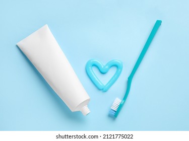 Heart Made Of Toothpaste, Tube And Brush On Blue Background