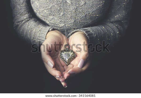 Heart necklace in woman\
hands