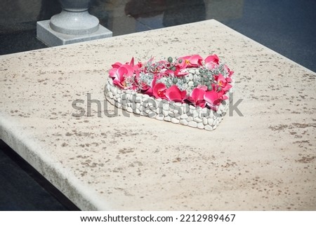 Heart on the headstone . Heart shaped bouquet at the tomb