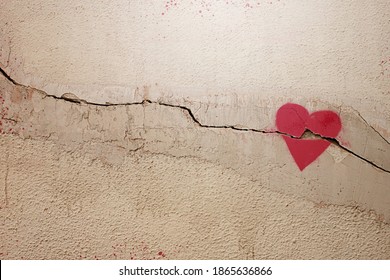 A heart painted on a cracked wall. The concept of broken heart, relationships, love, friendship, marriage, graffiti. - Shutterstock ID 1865636866