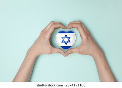 Heart with print of Israel flag in female hands. Flat lay. Copy space.