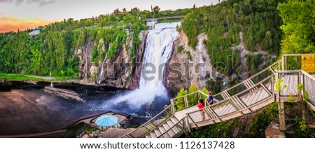 the heart of Quebec with this breathtaking photo of the Montmorency Falls. This stunning image captures the beauty and power of the large waterfall, set against the backdrop of the lush forest.