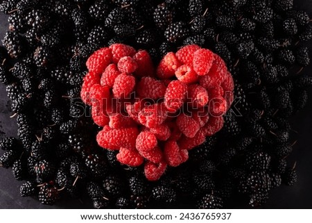 heart of raspberries on black berry texture